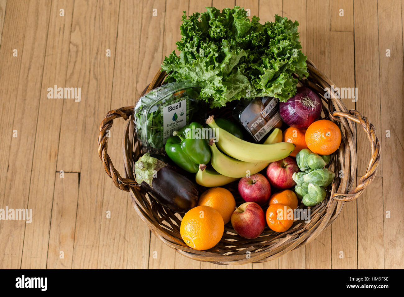 a variety of organic produce in a large woven basket Stock Photo