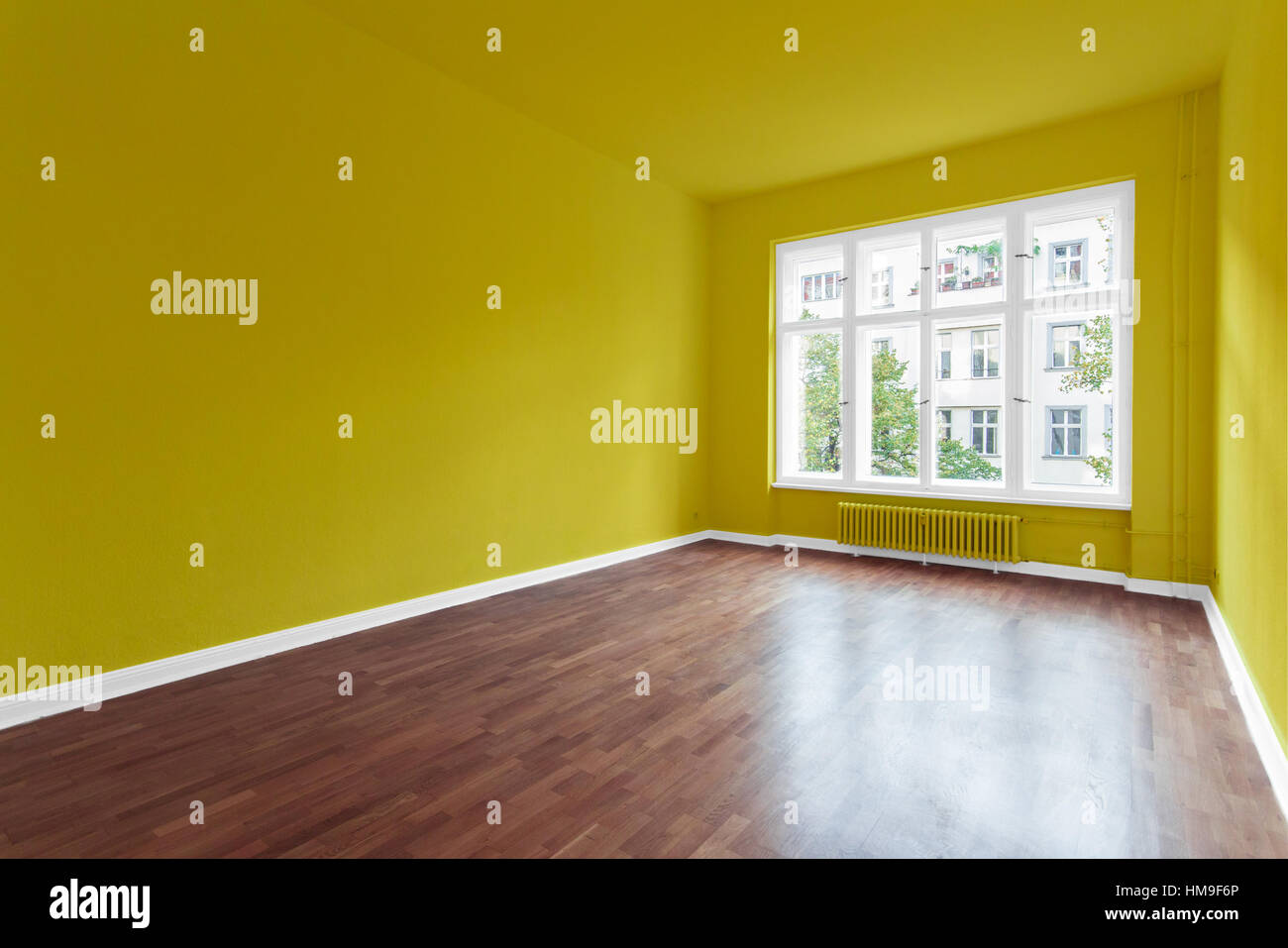 empty room with yellow walls and wooden floor Stock Photo