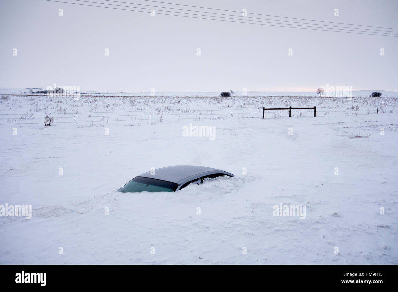 Car buried to its roof in deep snow not far from the road. North Dakota, USA Stock Photo