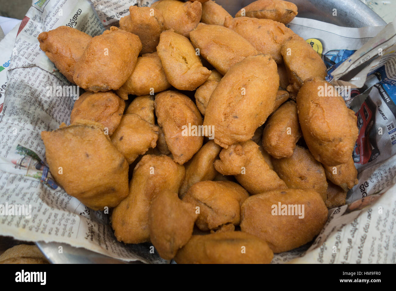 Sliced potato coated with gram flour batter and deep fried.Popular street food of India Stock Photo