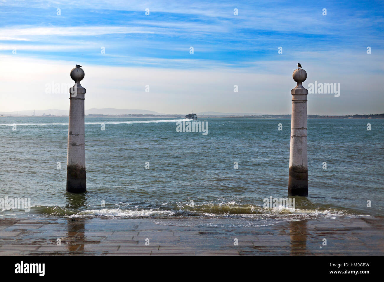 Cais das Colunas is a marble flight of steps, flanked by two water stained marble columns, which runs gently into the Tagus River in downtown Lisbon, Stock Photo