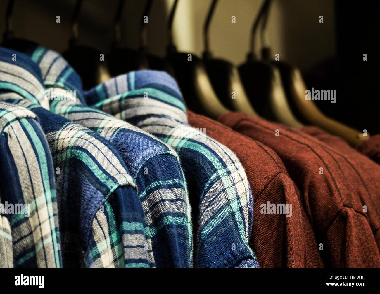 Row of shirt hanging in retail store Stock Photo - Alamy