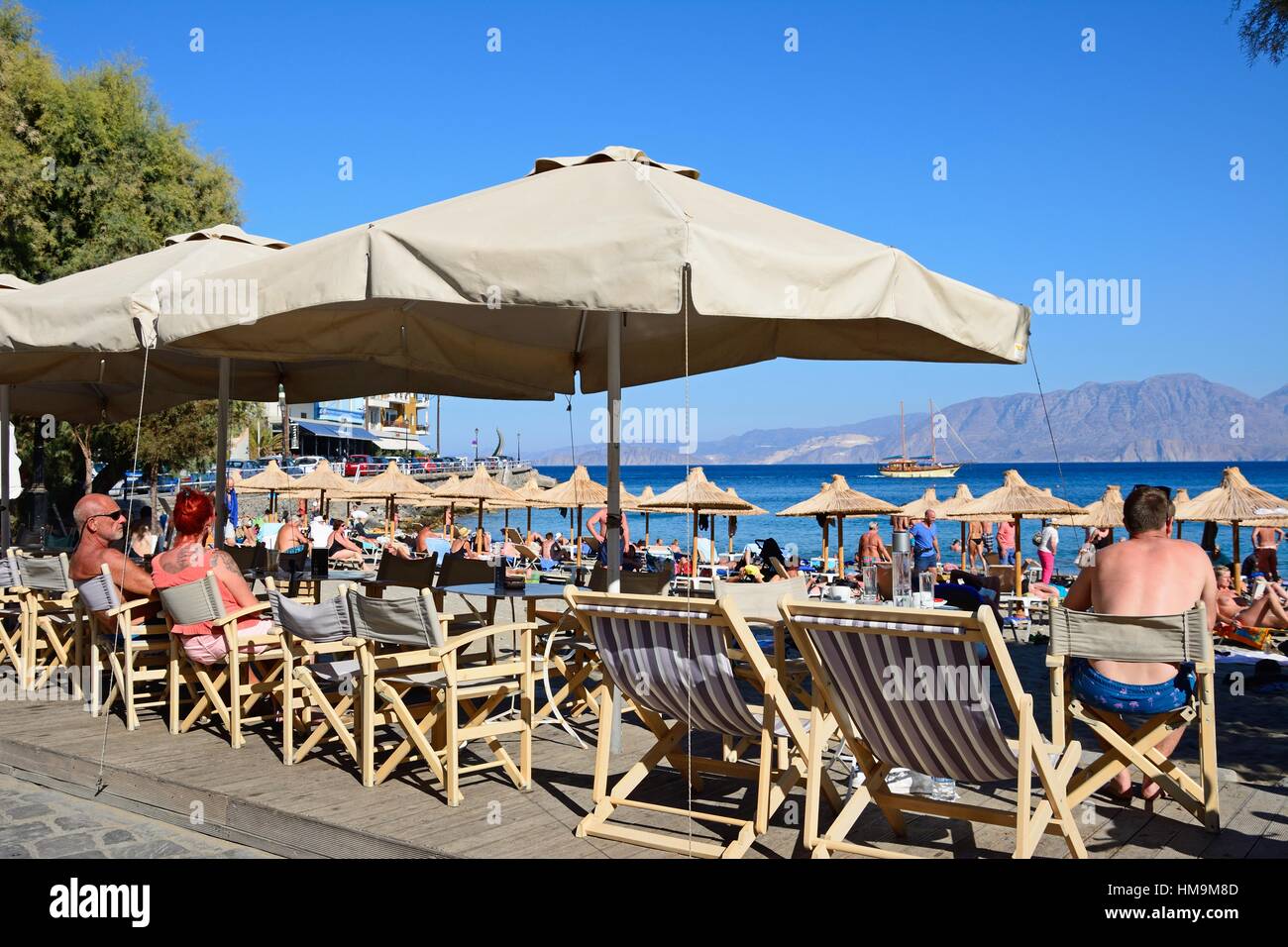 Tourists relaxing on the beach with beachside restaurants in the