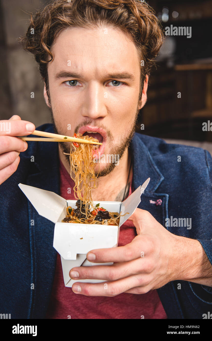 Man eating noodles Stock Photo