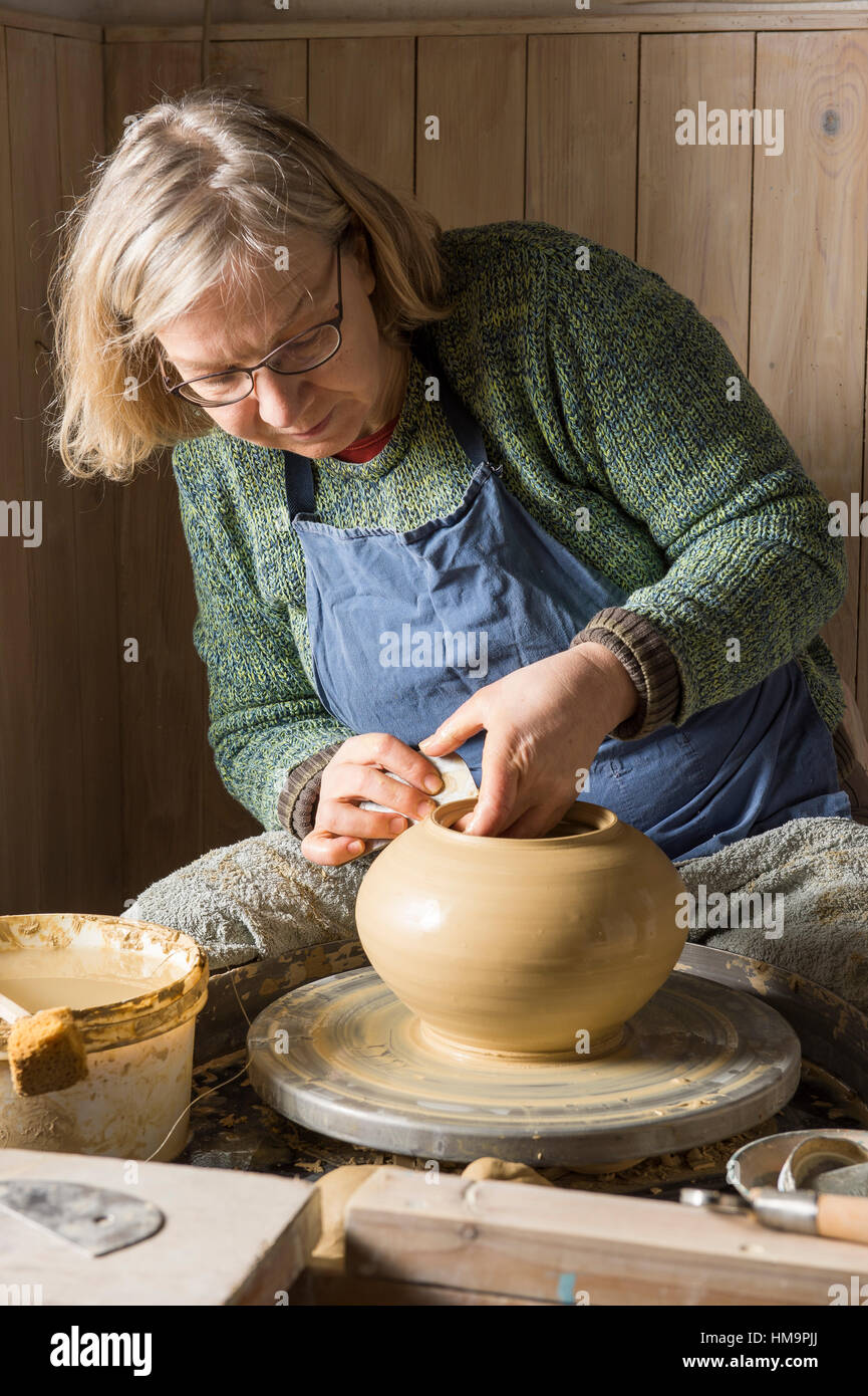 Ceramic workshop, woman working clay with rib on pottery wheel, Pittenhart, Upper Bavaria, Germany Stock Photo