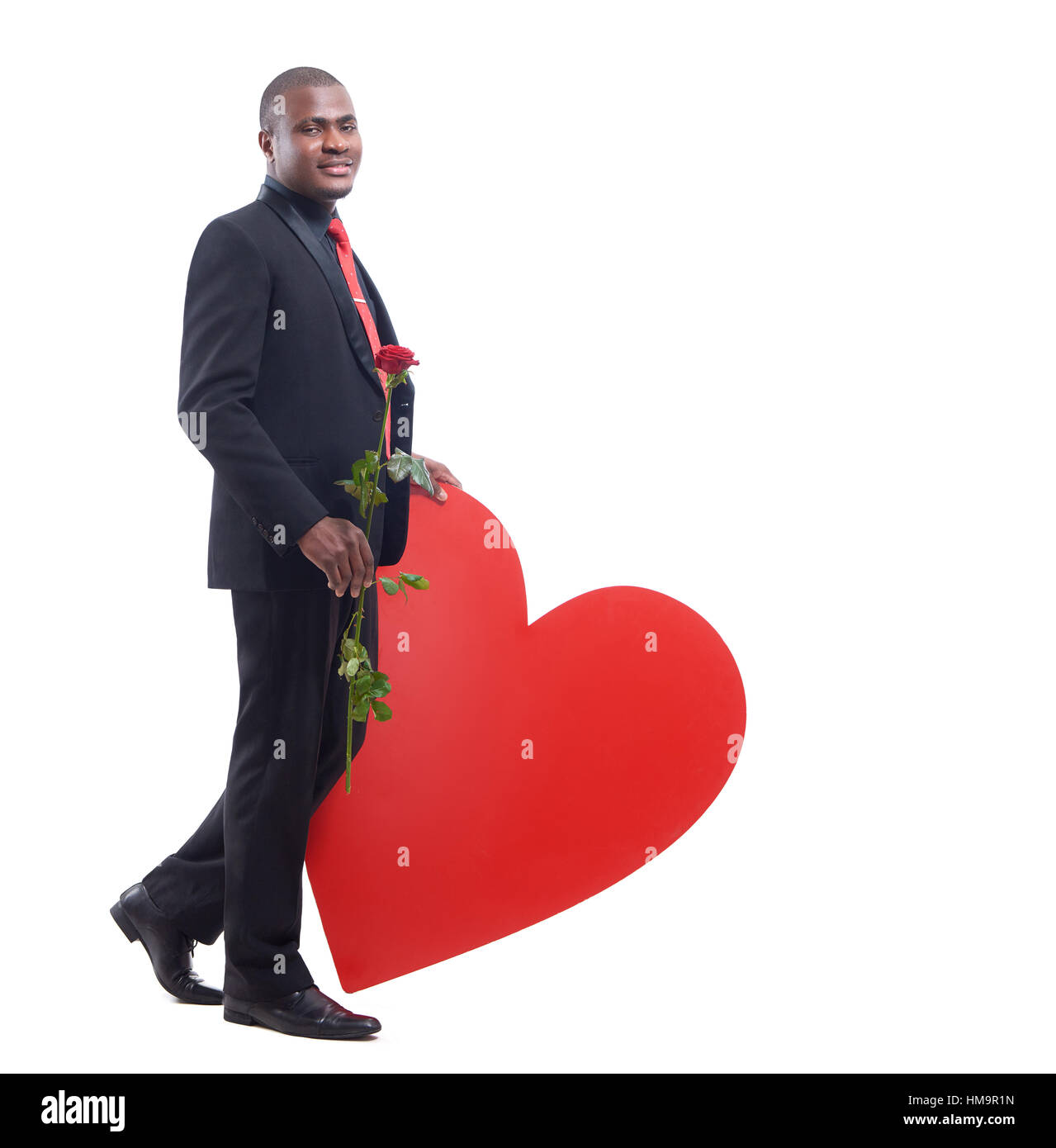 Male leaning of big red heart at studio. Stock Photo