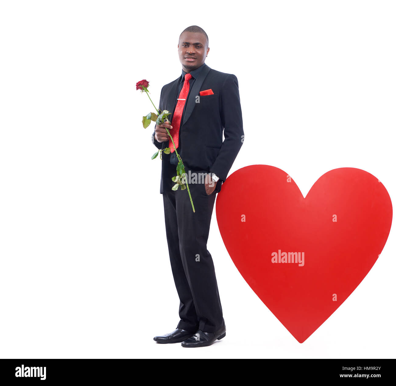 African business man posing and leaning of big heart. Stock Photo