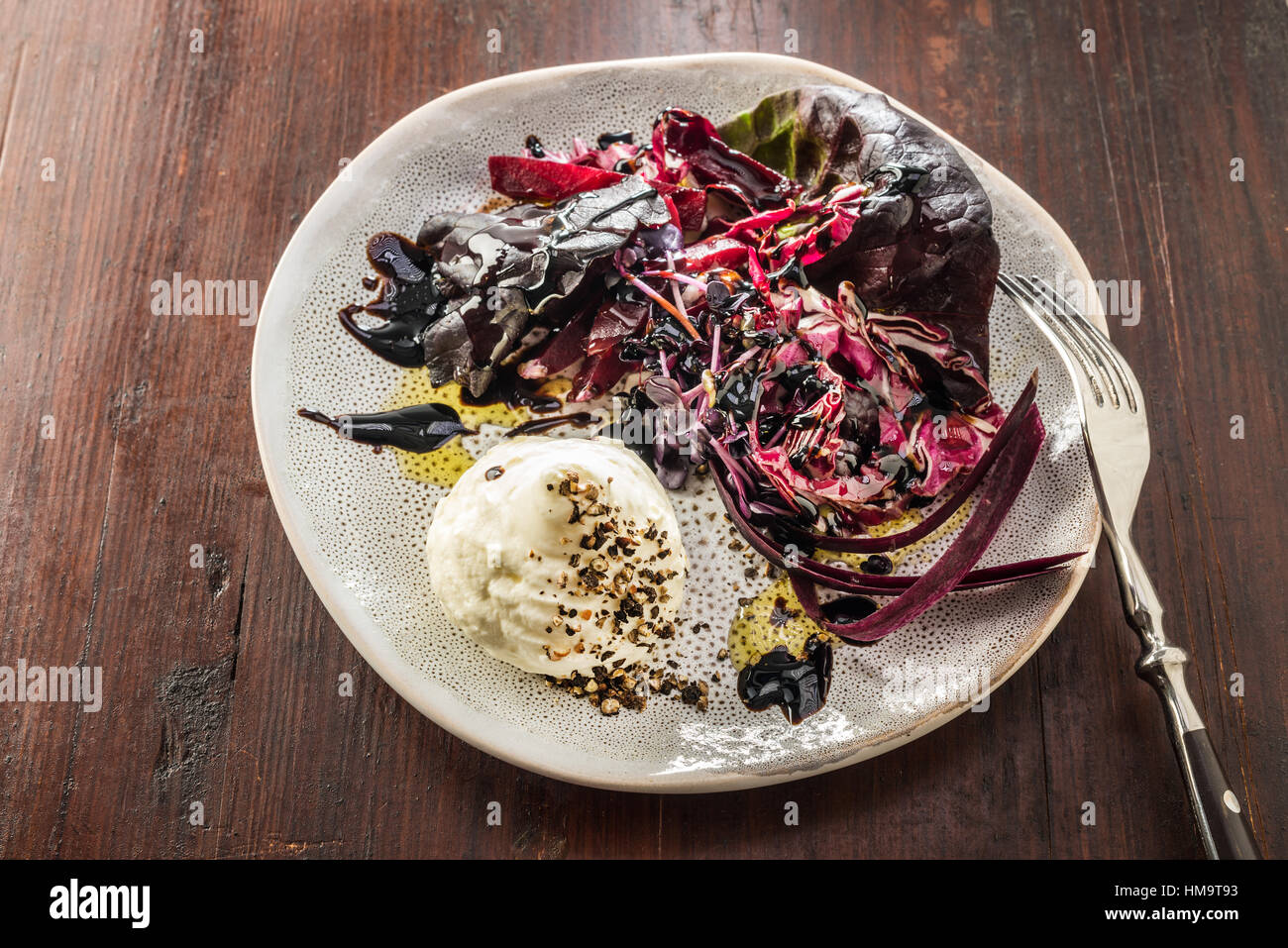 Red salads with goat's cheese on plate, vinegar oil salt pepper. sprouts Stock Photo