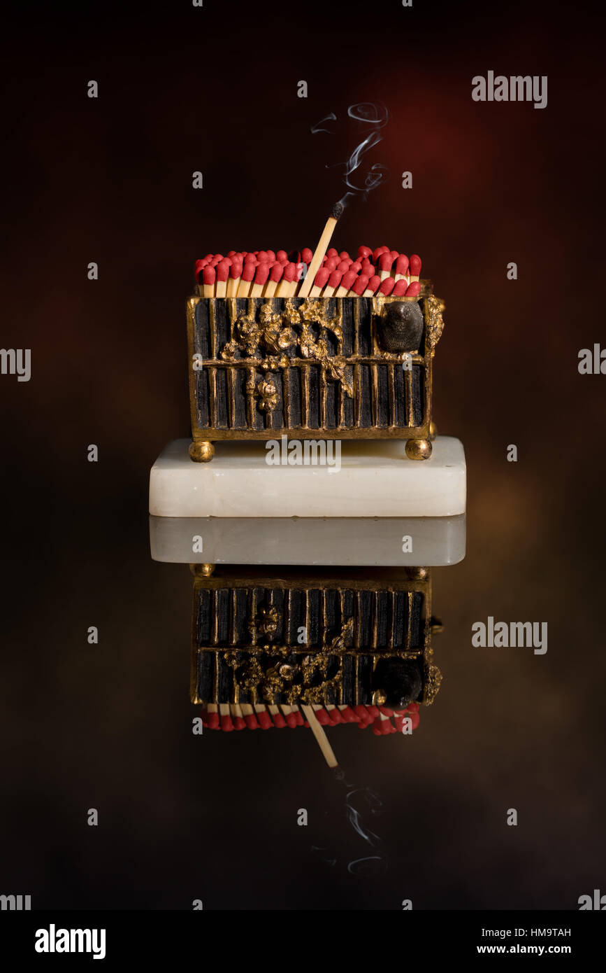 Antique vesta full of matches, one with smoke trail Stock Photo