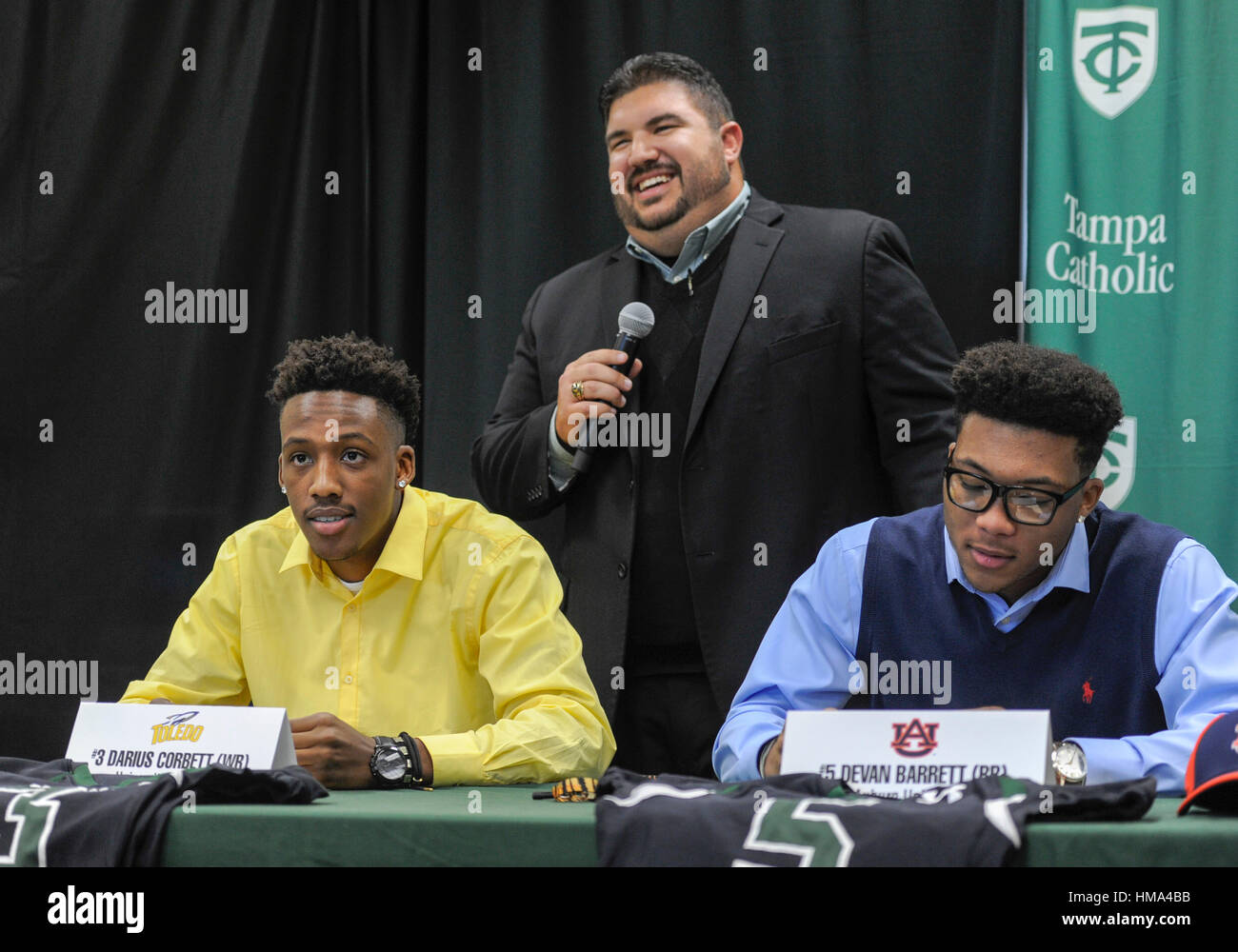 Tampa, USA. 1st Feb, 2017. Tampa Catholic football coach Mike Gregory, back, speaks as Darius Corbett, left, and Devan Barrett look during a National Signing Day ceremony held at the school in Tampa.Corbett who signed to University of Toledo, along with teammates Barrett, Auburn University, Austin Sessums, Texas Southern University and Steven Rix, Valdosta State University, and Bentlee Sanders, University of South Florida all signed during the event. Credit: Chris Urso/Tampa Bay Times/ZUMA Wire/Alamy Live News Stock Photo