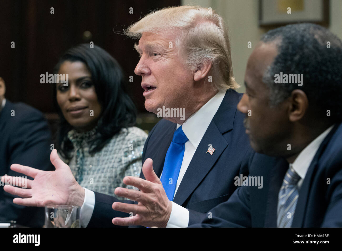 Washington, USA. 1st Feb, 2017. United States President Donald J. Trump (C) speaks between Director of Communications for the Office of Public Liaison Omarosa Manigault (L) and nominee to lead the Department of Housing and Urban Development (HUD) Ben Carson (R), during a meeting on African American History Month in the Roosevelt Room of the White House in Washington, DC, USA. Credit: Michael Reynolds/Pool via CNP /MediaPunch/ALamy Live News Stock Photo