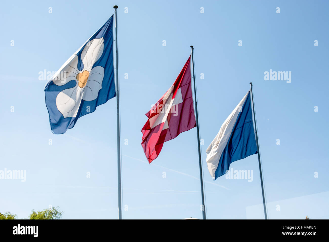 Flags of Zurich and Switzerland on flag poles on a summer day in Zurich with blue sky Stock Photo