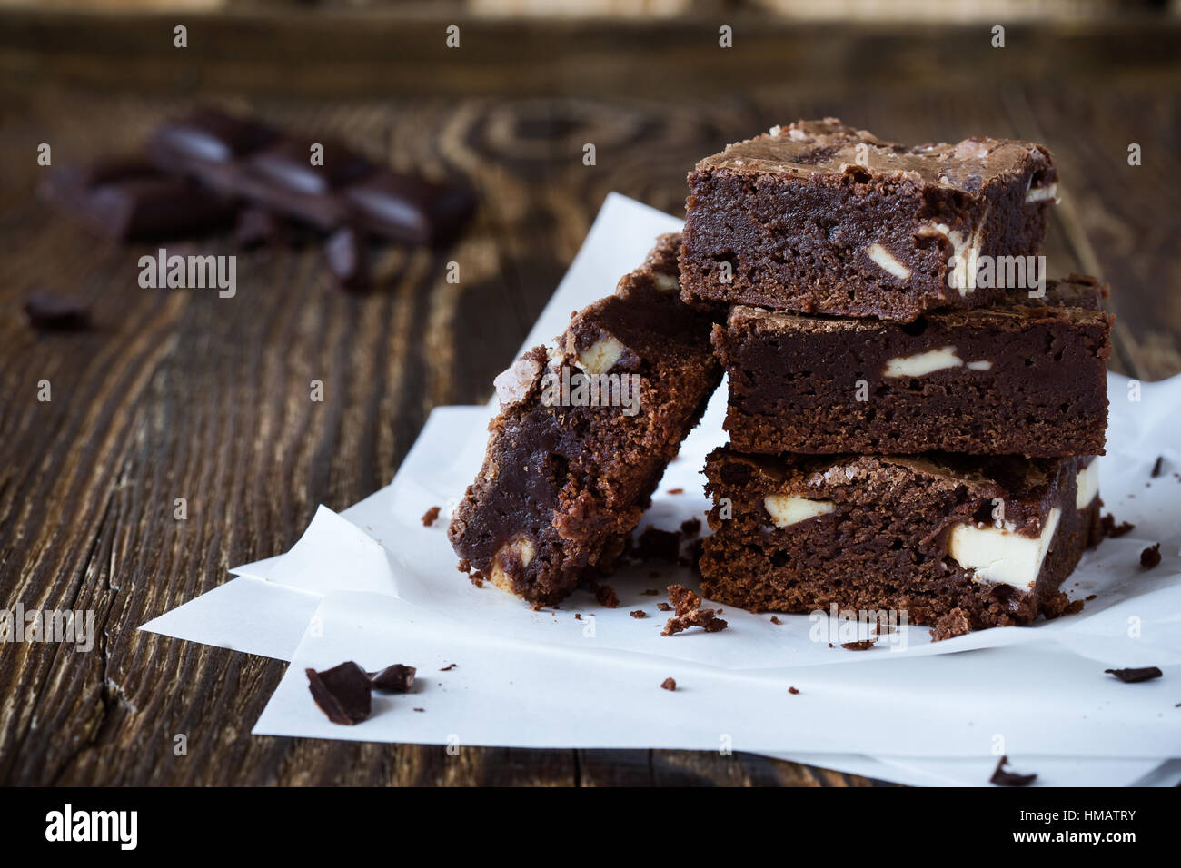 Homemade chocolate brownies with cream cheese on baking paper on rustic