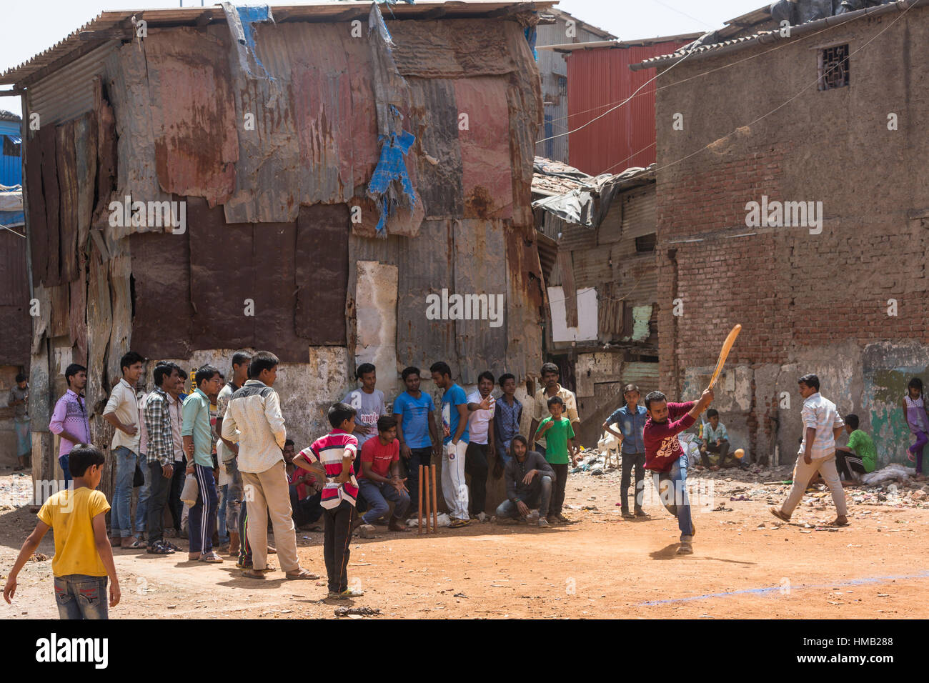 Children and teenagers playing cricket, national sport, Dharavi Slum, Mumbai, Maharashtra, India Stock Photo