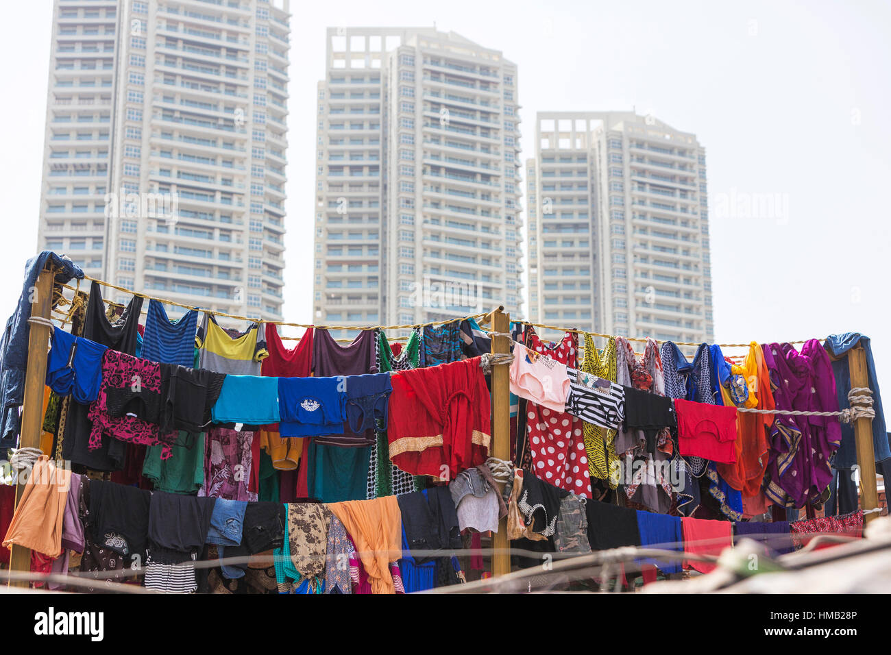 Colorful clothes on clothesline in front of skyscrapers, launderer's quarter Dhobi Ghat, Mahalaxmi, Mumbai, Maharashtra, India Stock Photo