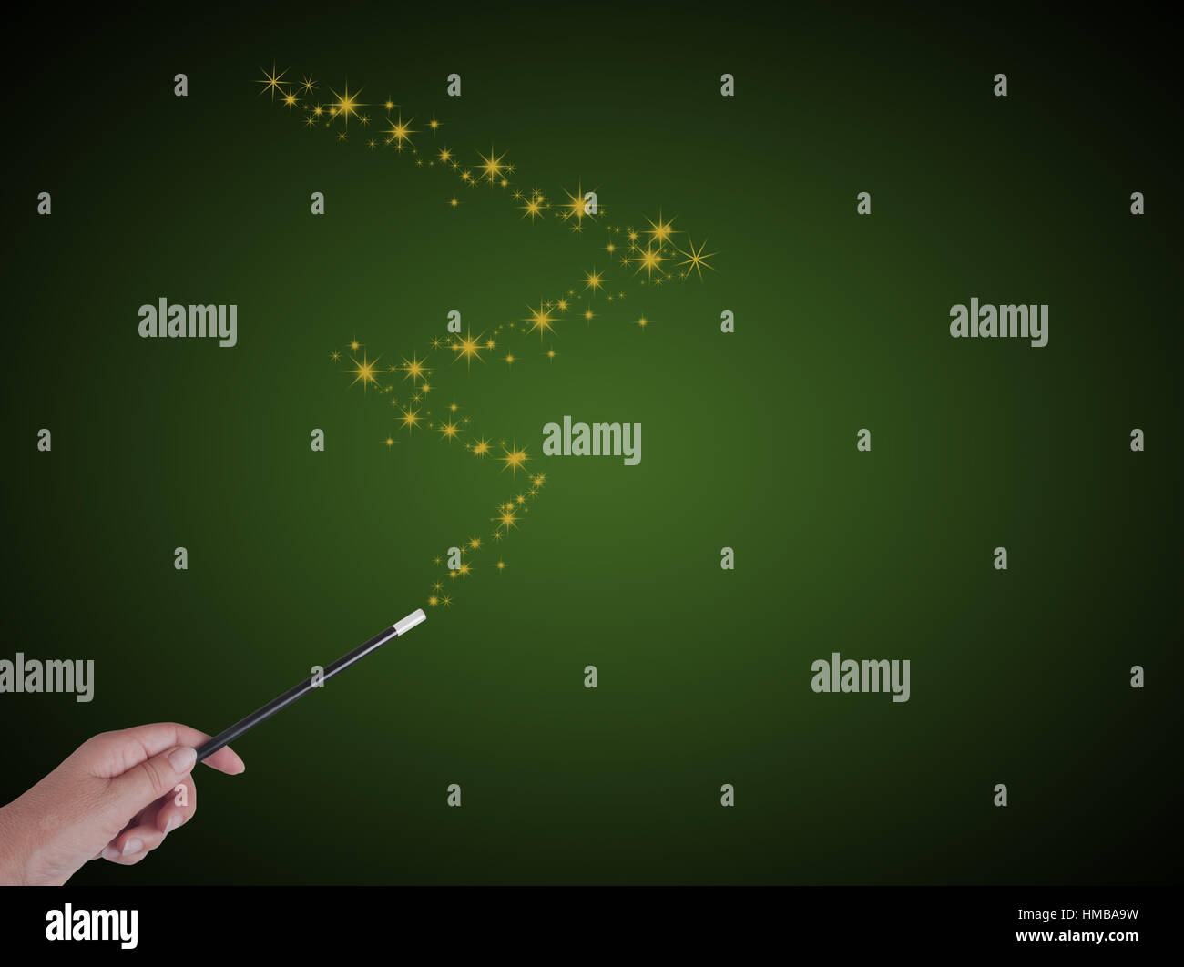 Magician with magic wand and stars on green. With copyspace, for magical results. Stock Photo