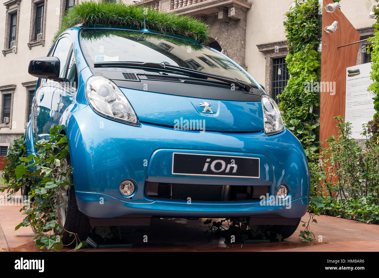 Street presentation of electric Peugeot iOn car in Milan, Italy. The main concept is how environmentally friendly are the electric cars compared to tr Stock Photo