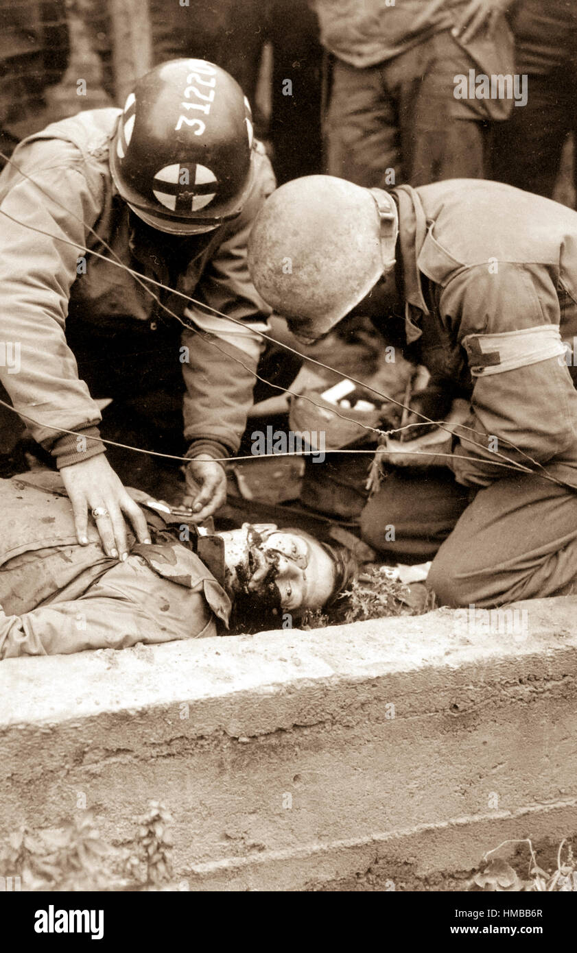 American soldier lies dead in gutter of Schevenhutte, Germany, after being hit by flak from German guns.  Medics had just given first aid, to no avail.  December 22, 1944.  Sgt. J. A. DeMarco.  (Army Surgeon General) NARA FILE #:  112-SGA-44-30564 WAR & CONFLICT BOOK #:  1341 Stock Photo