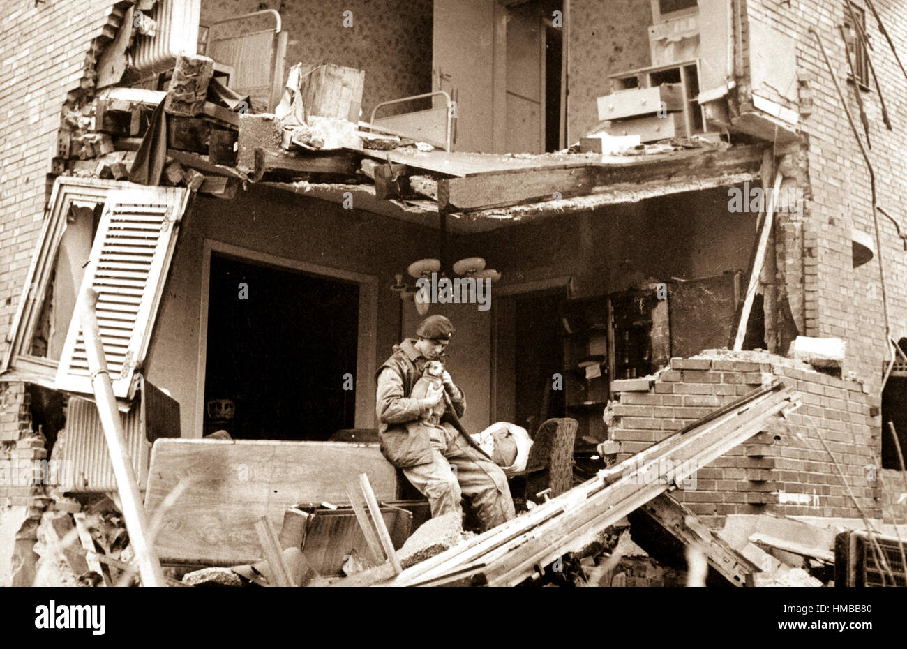 British Trooper W. Williamson does his good deed for the day by rescuing a puppy dog from the ruins of a shelled German house on the outskirts of Geilenkirchen.  Ca.  November 1944.  British Official.  New York Times Paris Bureau Collection.  (USIA) Exact Date Shot Unknown NARA FILE #:  306-NT-901-74 WAR & CONFLICT BOOK #:  1089 Stock Photo