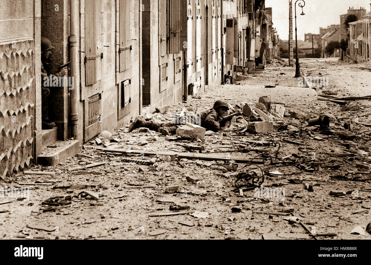 Americans take shelter during mop-up of Brest.  Crouching behind a pile of rubble, a U.S. soldier watches for German snipers in the streets of Brest, while a companion covers him from behind a doorway.  September 1944.  INP.  (OWI) Exact Date Shot Unknown NARA FILE #:  208-AA-19Z-1 WAR & CONFLICT BOOK #:  1054 Stock Photo