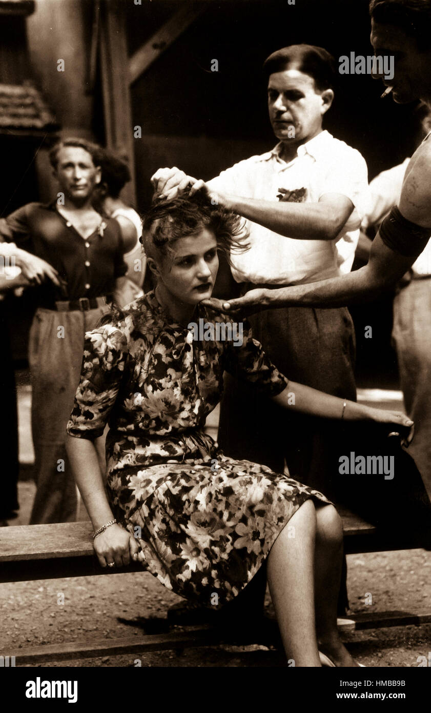 This girl pays the penalty for having had personal relations with the Germans.  Here, in the Montelimar area, France, French civilians shave her head as punishment.  August 20, 1944. Smith.  (Army) Exact Date Shot Unknown NARA FILE #:  111-SC-193785 WAR & CONFLICT BOOK #:  1259 Stock Photo