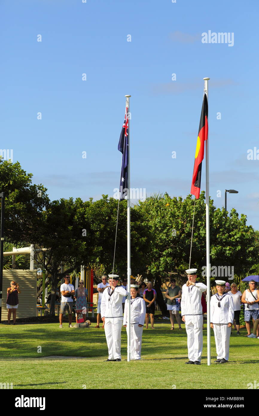 Navy and Police Cadets honour guard stand at attention in front of Australia and Aboriginal Flags on Australia Day at Kings Beach in QLD, Australia. Stock Photo