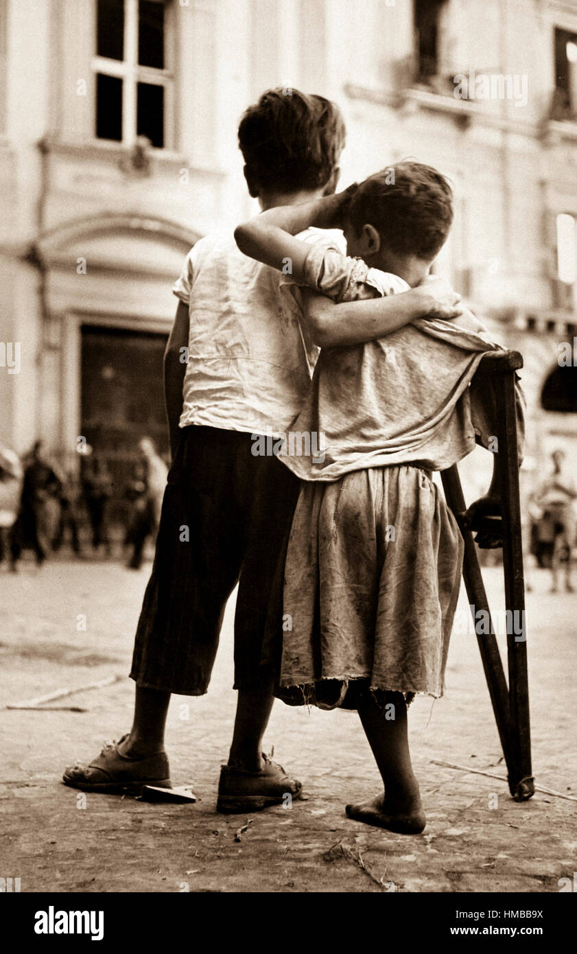 Children in Naples, Italy.  Little boy helps one-legged companion across street, August 1944. Lt. Wayne Miller. (Navy) Exact Date Shot Unknown NARA FILE #:  080-G-474128 WAR & CONFLICT BOOK #:  1260 Stock Photo
