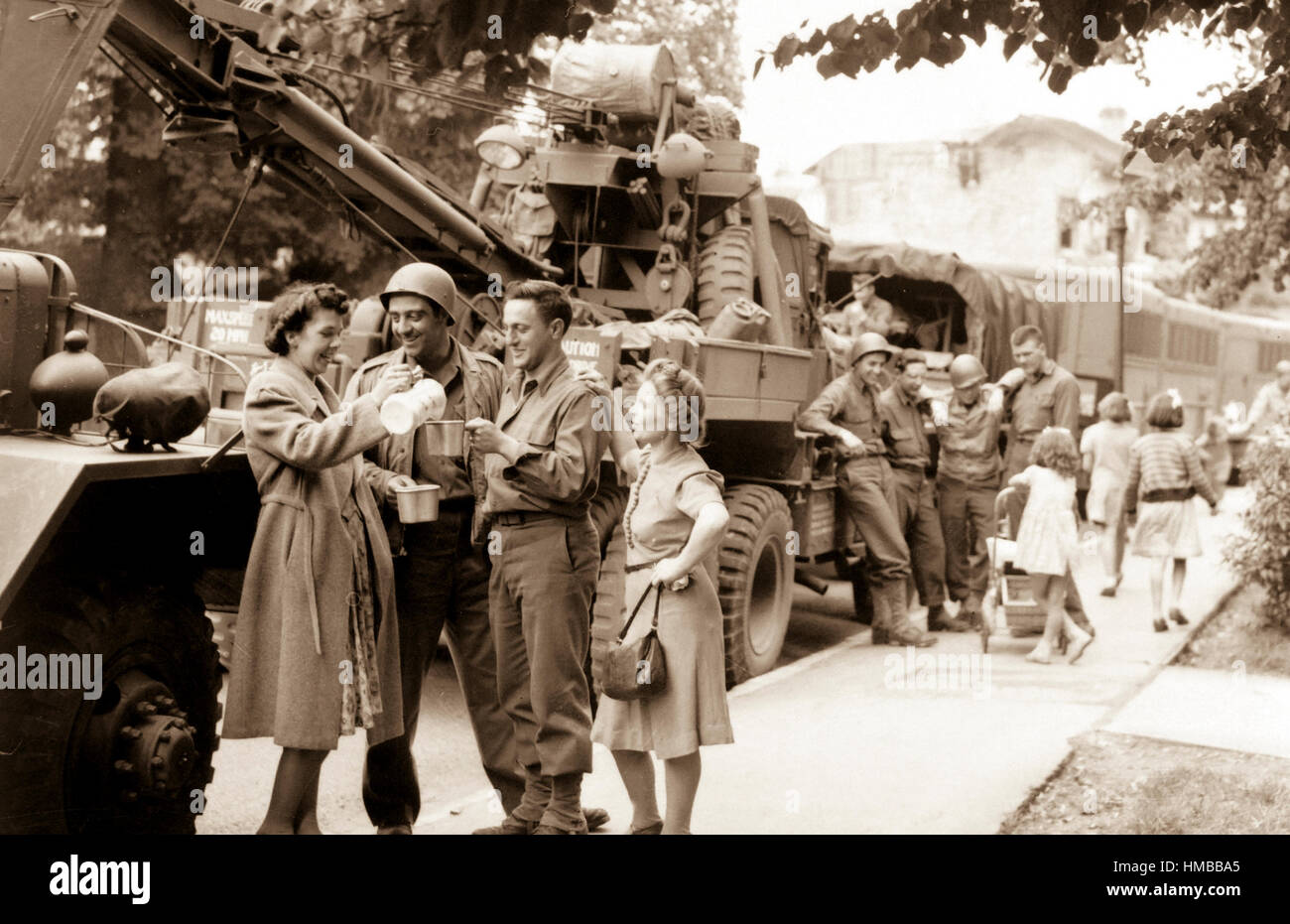 Army Ordnance men await the 'go' signal for cross channel trip to France.  British civilians serve hot coffee as the men await the word to move out in an English town.  July 24, 1944. Messerlin. (Army) Exact Date Shot Unknown NARA FILE #:  111-SC-191728 WAR & CONFLICT BOOK #:  1255 Stock Photo