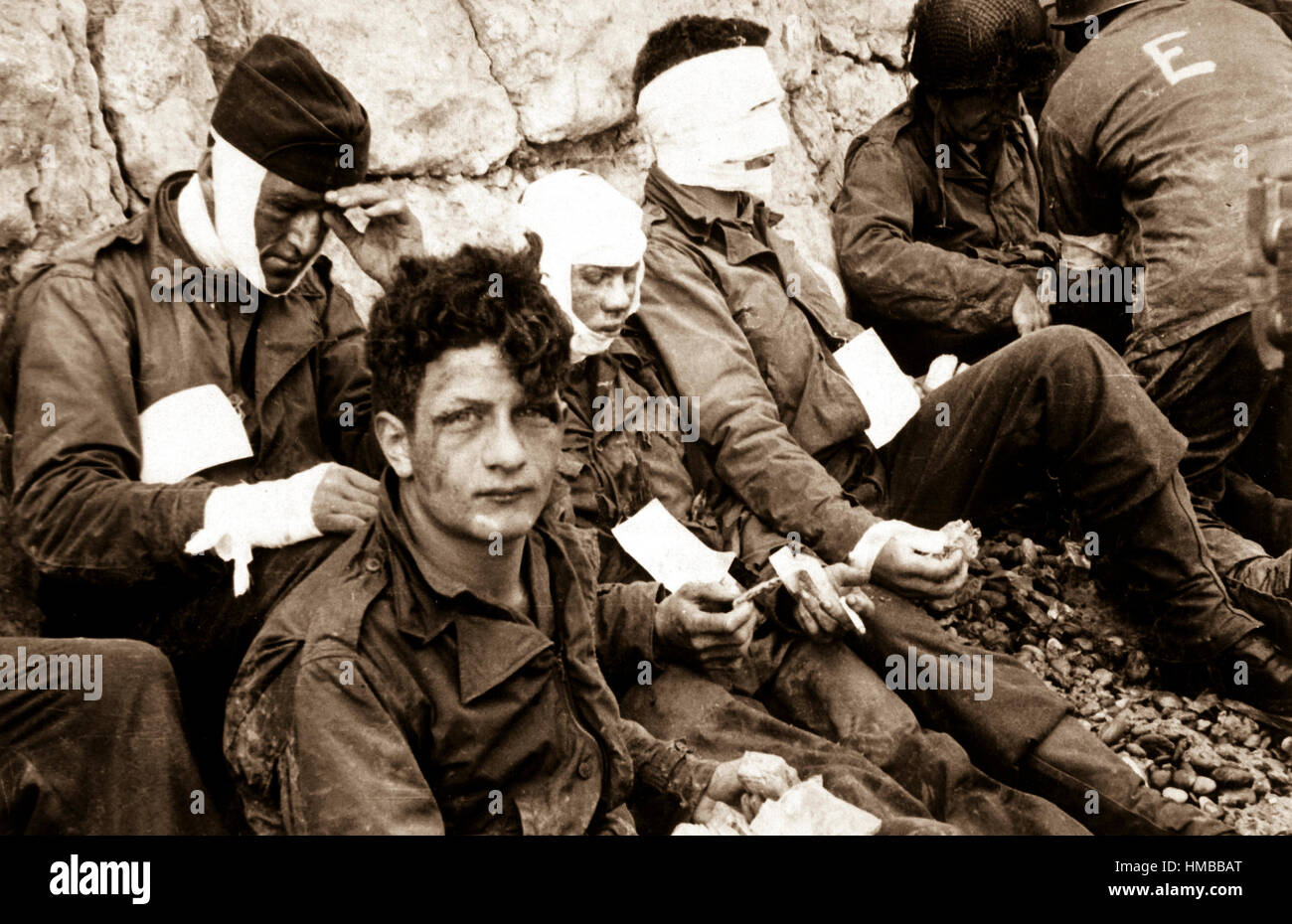 American assault troops of the 16th Infantry Regiment, injured while storming Omaha Beach, wait for the Chalk Cliffs for evacuation to a field hospital for further medical treatment.  Collville-sur-Mer, Normandy, France.  June 6, 1944.  Taylor.  (Army) NARA FILE #:  111-SC-189910 WAR & CONFLICT BOOK #:  1043 Stock Photo