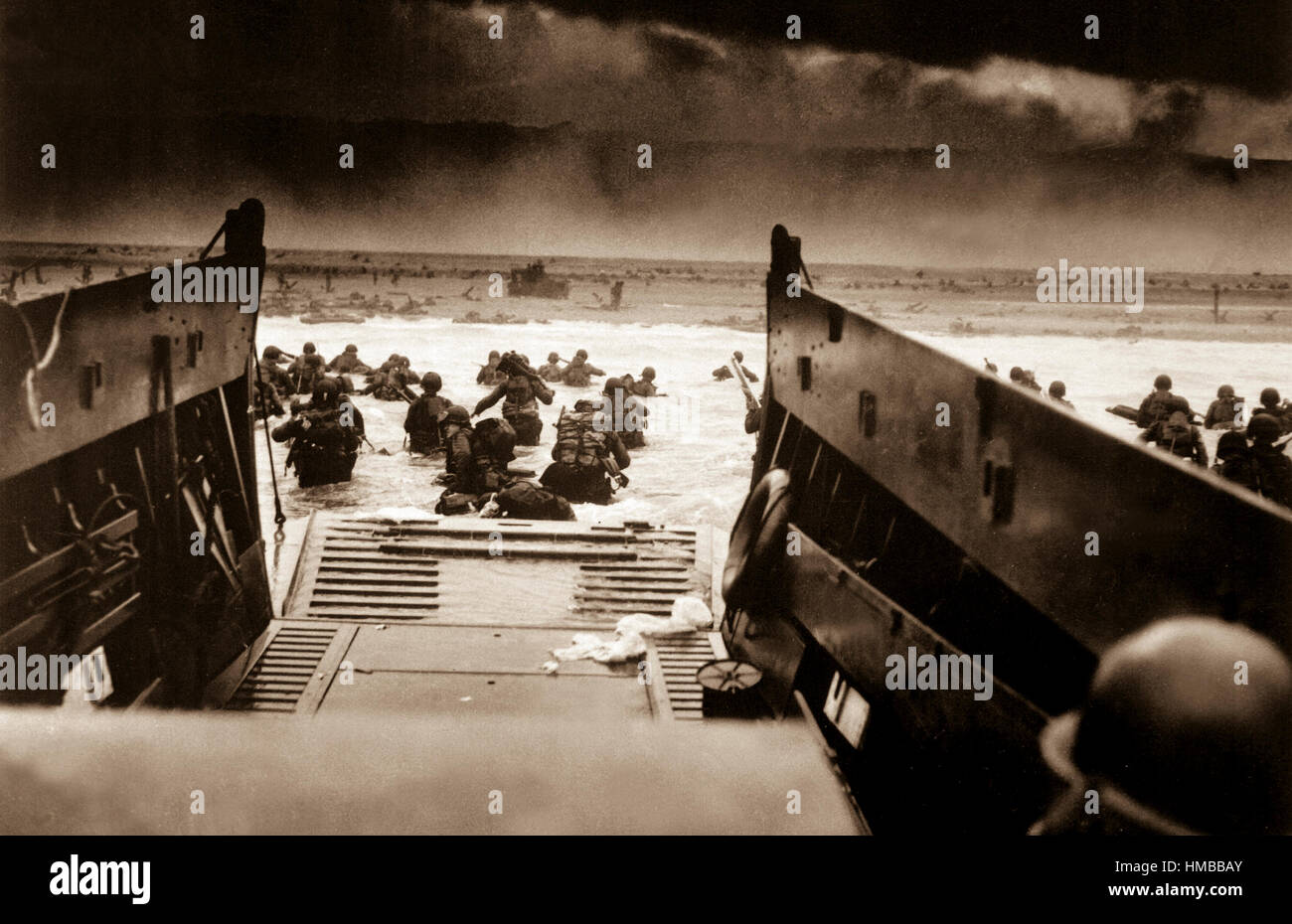 Landing on the coast of France under heavy Nazi machine gun fire are these American soldiers, shown just as they left the ramp of a Coast Guard landing boat, June 6, 1944.  CPhoM. Robert F. Sargent. (Coast Guard) NARA FILE #:  026-G-2343 WAR & CONFLICT BOOK #:  1041 Stock Photo