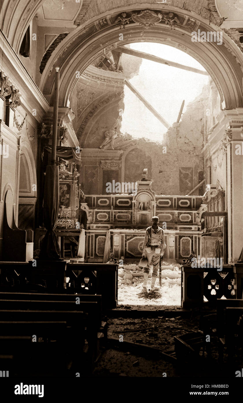 Pvt. Paul Oglesby, 30th Inf., standing in reverence before an altar in a damaged Catholic Church.  Note: pews at left appear undamaged, while bomb-shattered roof is strewn about the sanctuary.  Acerno, Italy.  September 23, 1943.  Benson. (Army) NARA FILE #:  111-SC-188691 WAR & CONFLICT BOOK #:  1033 Stock Photo