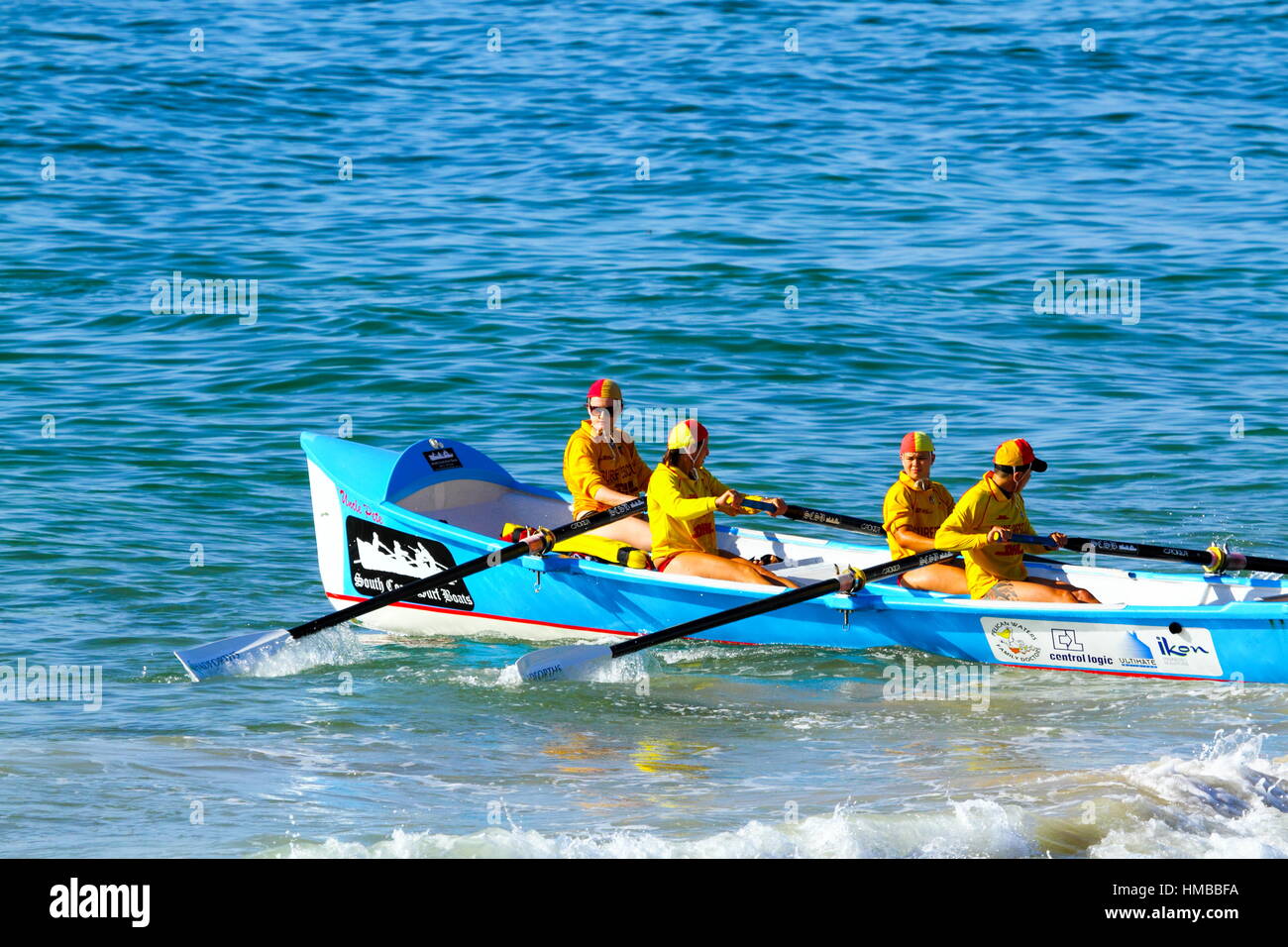 Four Surf Lifesavers launching a surf boat for some training at Kings Beach on the Sunshine Coast of Queensland, Australia. Stock Photo
