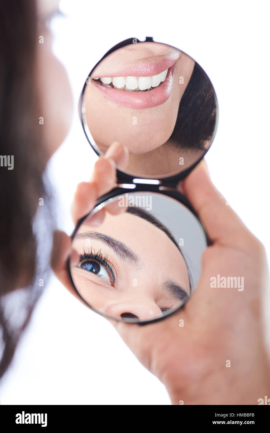 girl's smile and eye reflection on a hand mirror Stock Photo