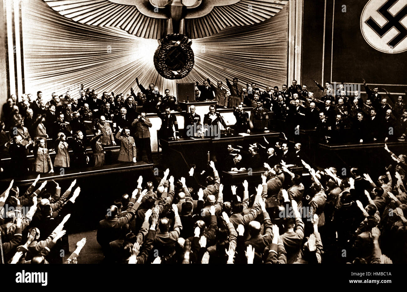 Hitler accepts the ovation of the Reichstag after announcing the 'peaceful' acquisition of Austria.  It set the stage to annex the Czechoslovakian Sudetenland, largely inhabited by a German-speaking population.  Berlin, March 1938.  (OWI) Exact Date Shot Unknown NARA FILE #:  208-N-39843 WAR & CONFLICT BOOK #:  988 Stock Photo