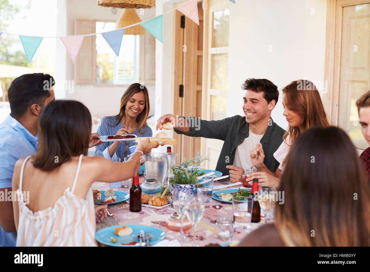 Friends serving each other at a patio dinner party, close up Stock Photo
