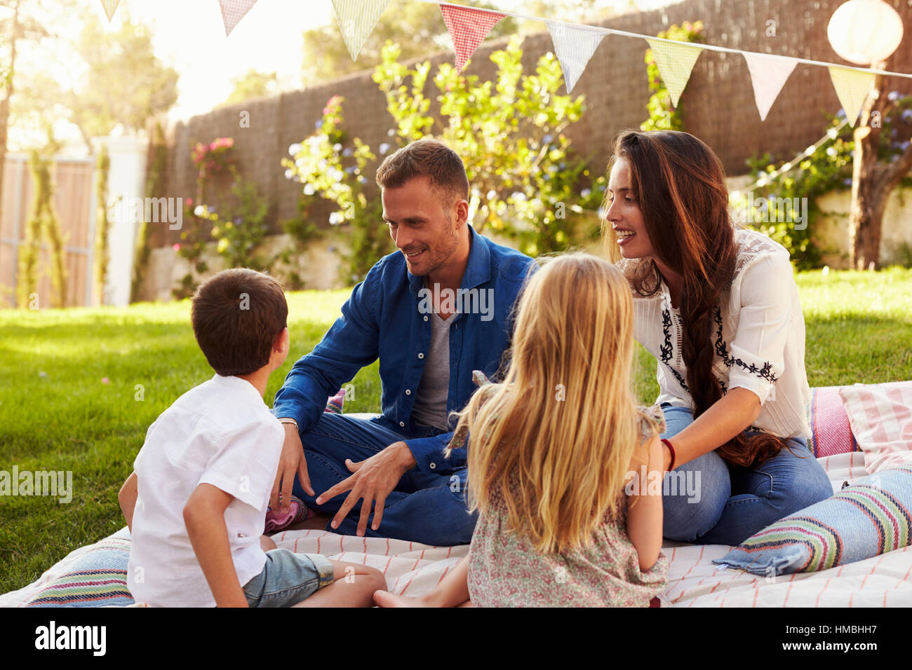 Family Relaxing On Blanket In Garden Stock Photo Alamy