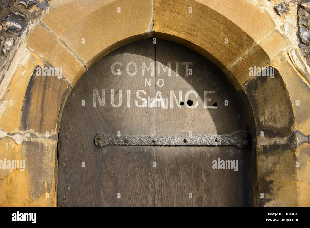 Old door with 'Commit No Nuisance' warning at the clock tower in St Albans, United Kingdom Stock Photo
