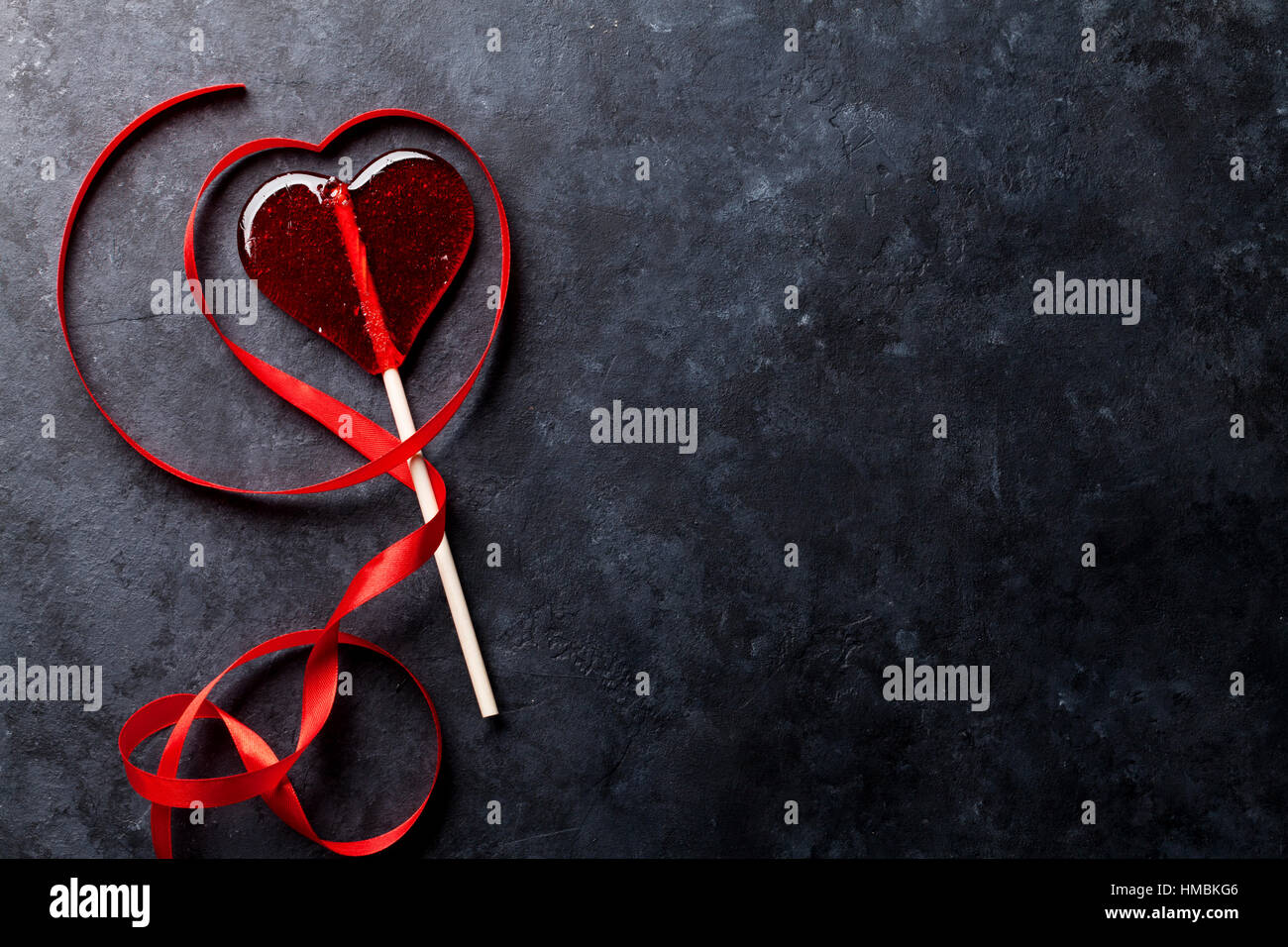 Valentines day greeting card. Candy heart and red ribbon on stone table ...