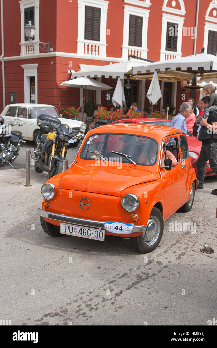 NOVIGRAD, CROATIA - SEPTEMBER 13, 2014: Unrecognizable people watch the parade of vintage cars on the narrow streets on 5th International Old Timer Ca Stock Photo