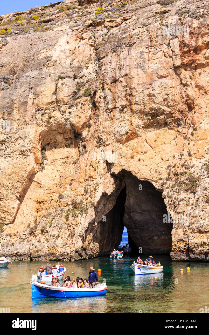excursion boats travelling from the inland lagoon through the arch to the azure window, gozo, malta Stock Photo