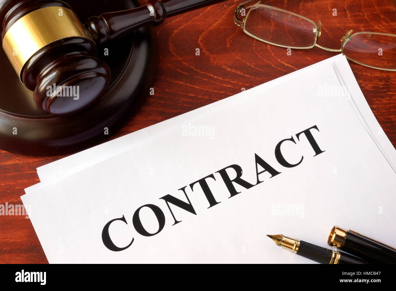 A contract and a gavel on a table. Stock Photo