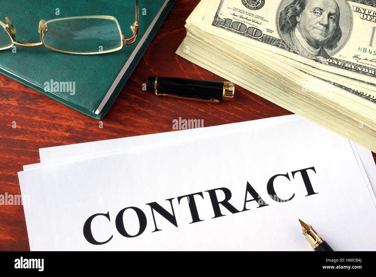 Business contract and money on a table. Stock Photo