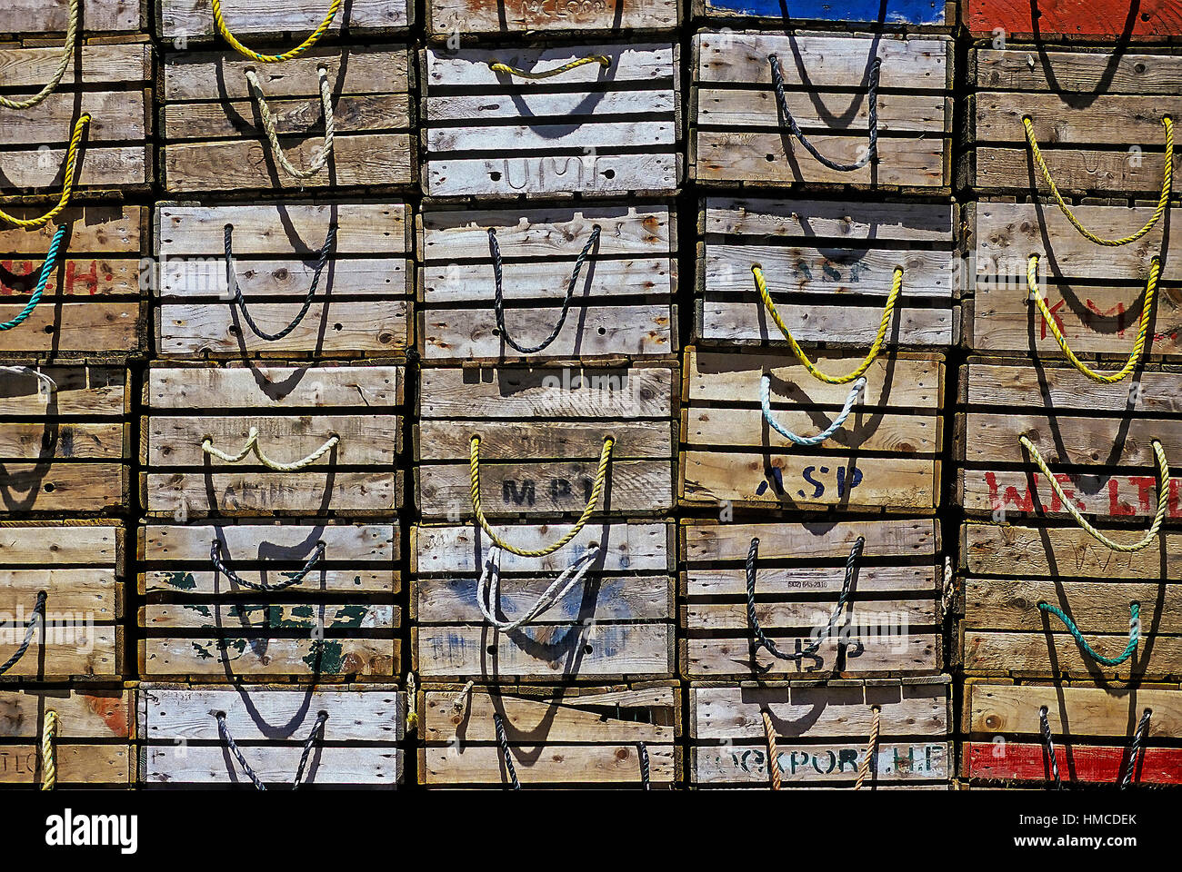 Rows of wooden fish boxes with rope handles are stacked on top of each