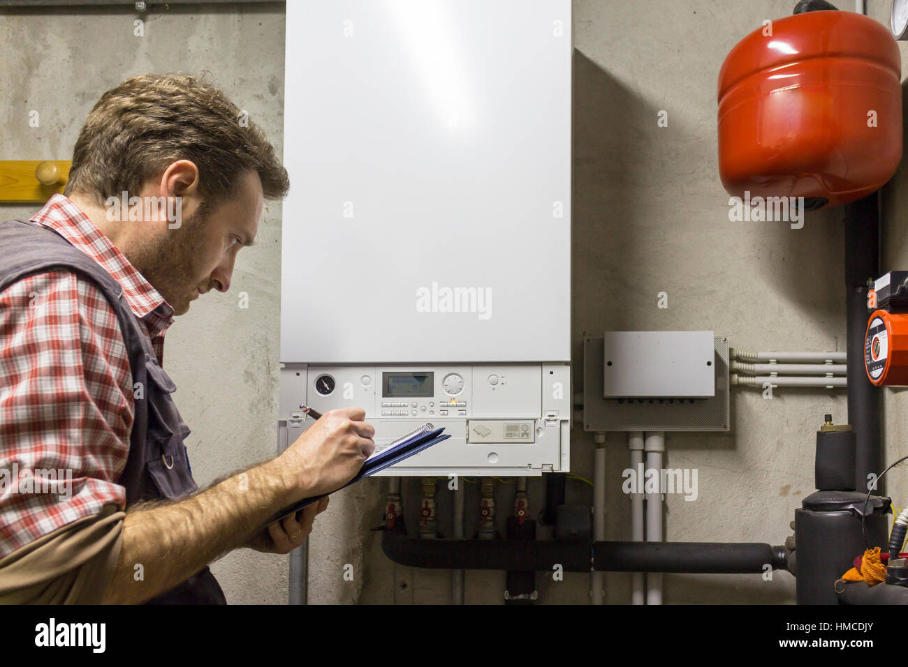 plumber who carries out the maintenance of a condensing boiler Stock Photo