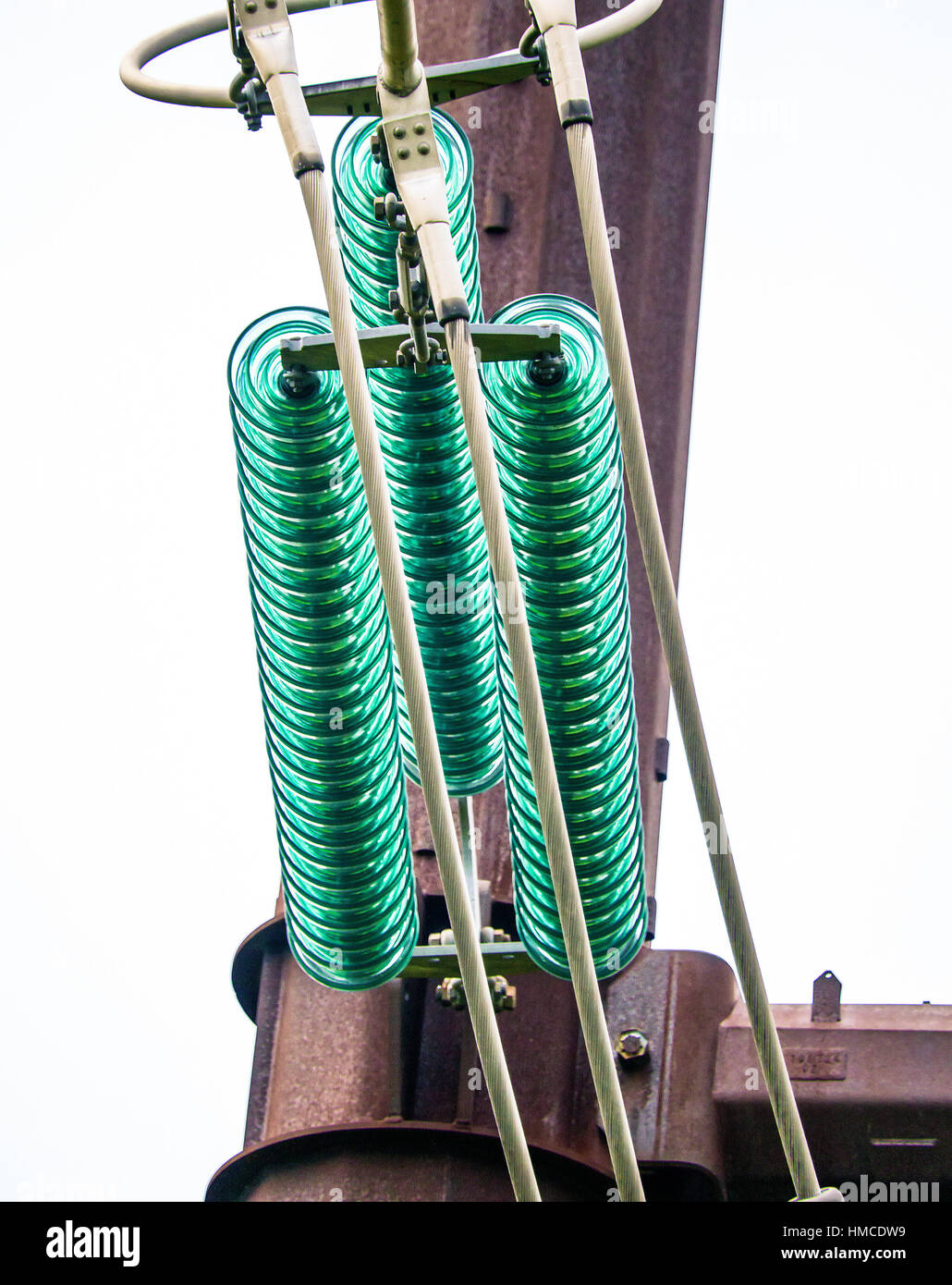 Closeup of high power line aqua colored glass insulators. Stock Photo