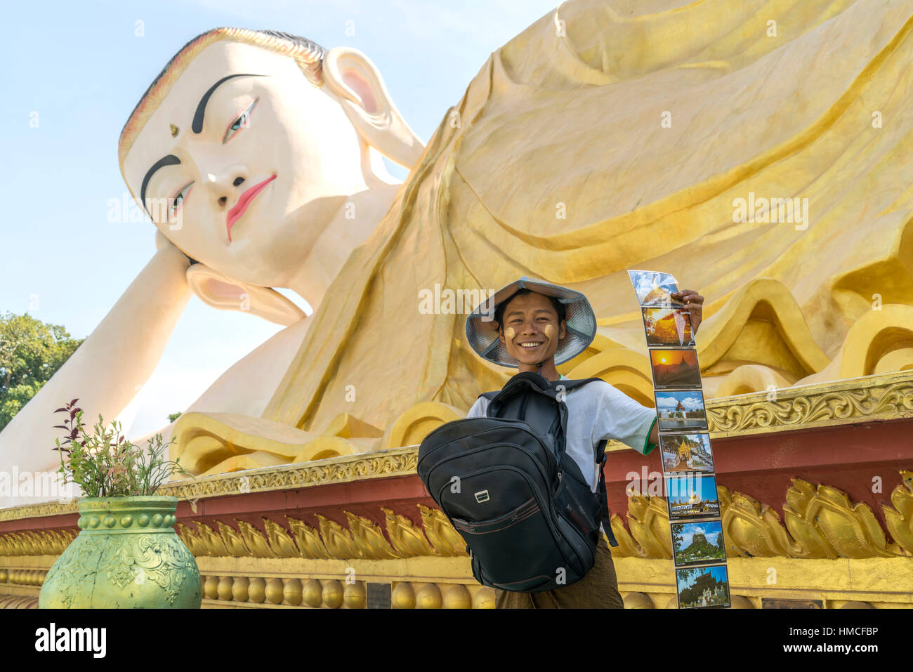 boy selling postcards at the giant Myatharlyaung Reclining Buddha Image in Bago, Myanmar, Asia Stock Photo