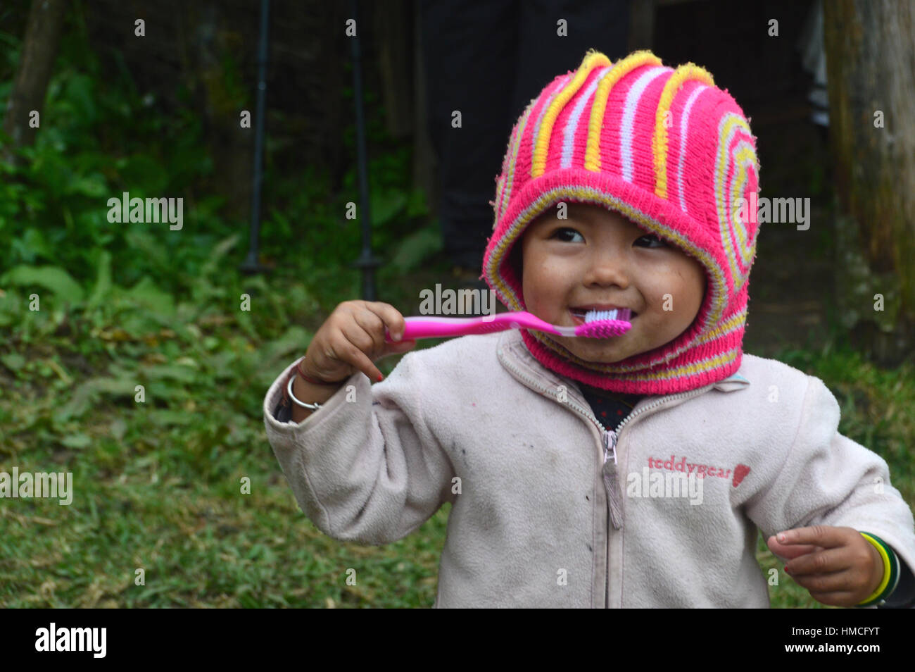 Nepalese Infant Girl with Toothbrush Outside School near Chomrong Annapurna Base Camp (ABC)  Annapurna Sanctuary, Himalayas, Nepal, Asia. Stock Photo