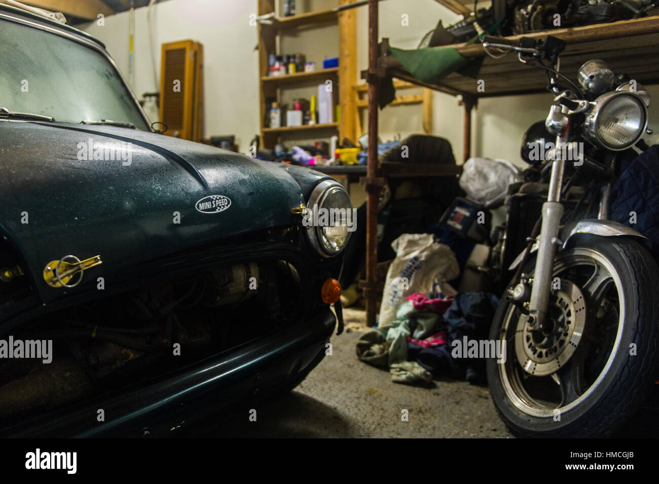 Classic Austin Mini Cooper and Kawasaki Motorbike in a domestic garage/workshop. Stock Photo