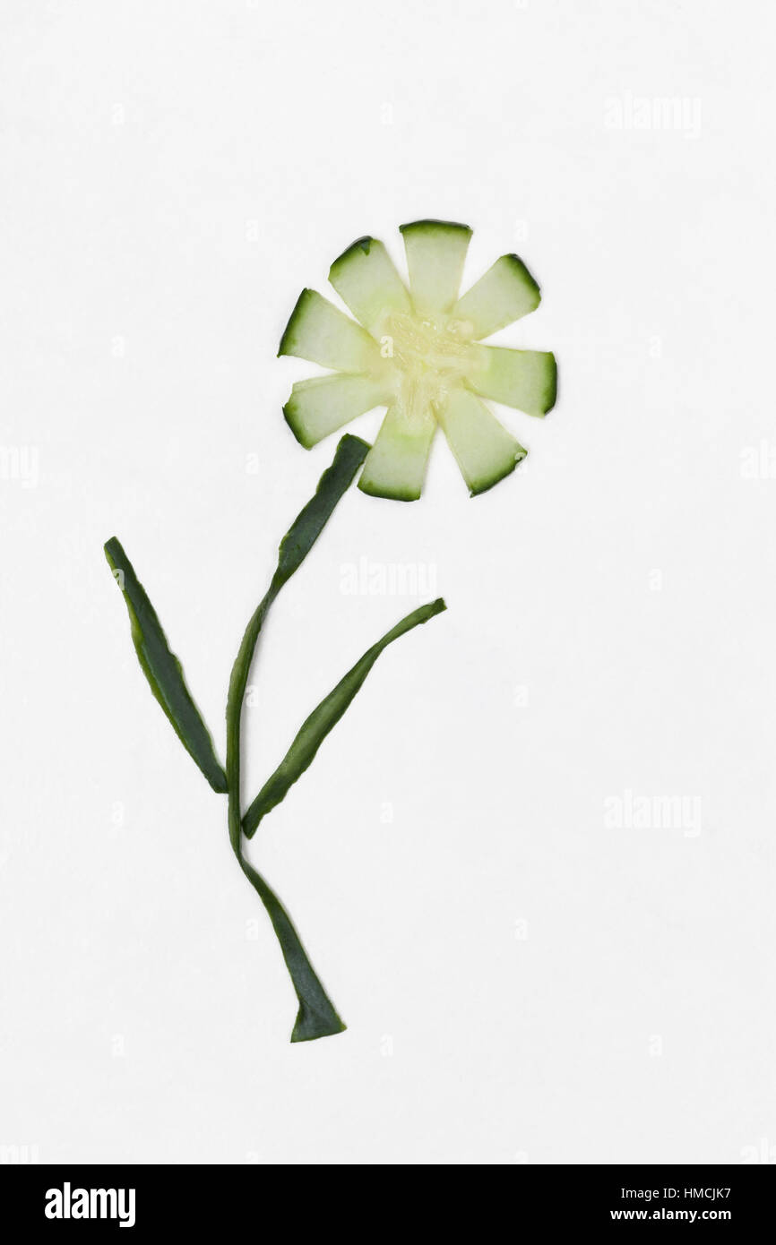 Flower made from cucumber slice with spring onion stem and leaves Stock Photo