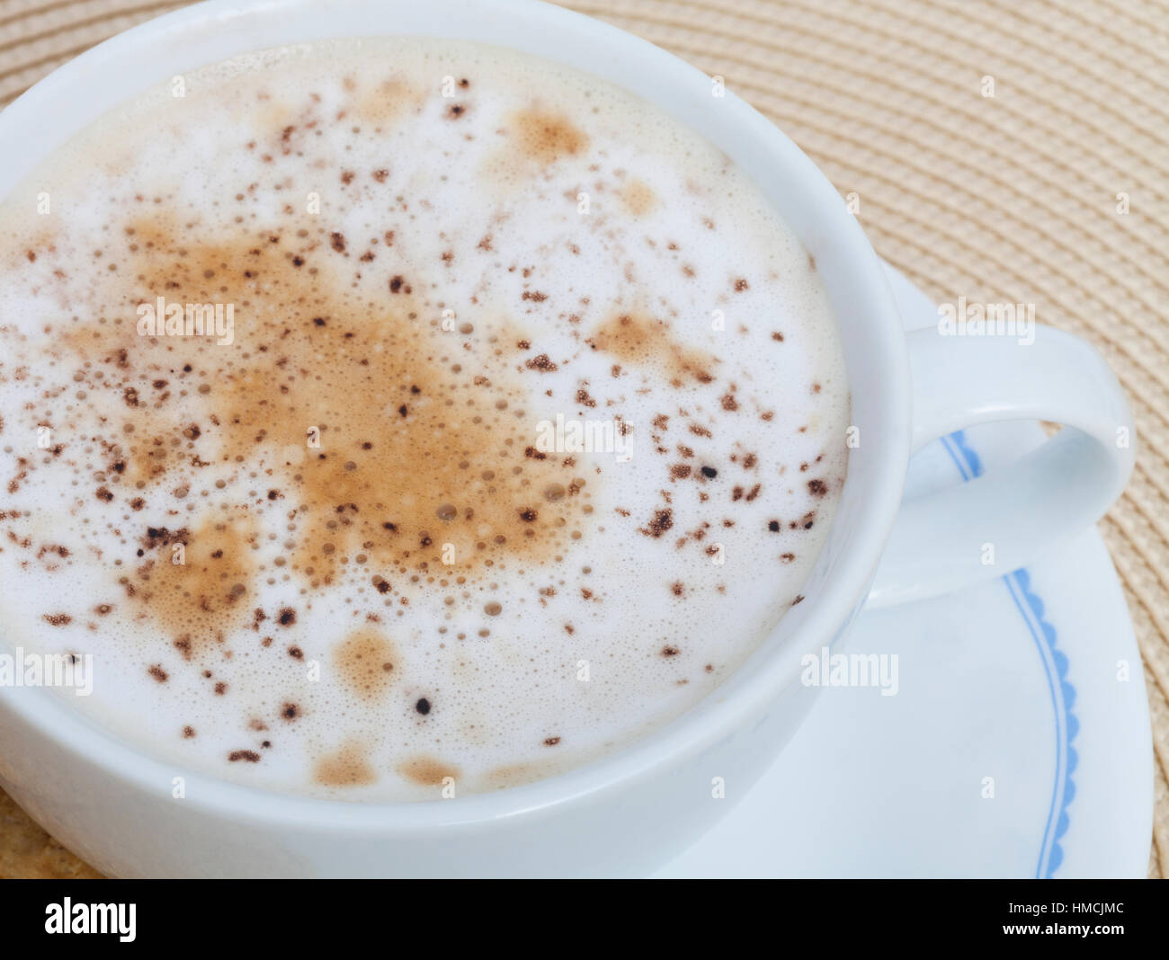 A cup of cappuccino with cocoa powder sprinkles in the milk foam Stock Photo